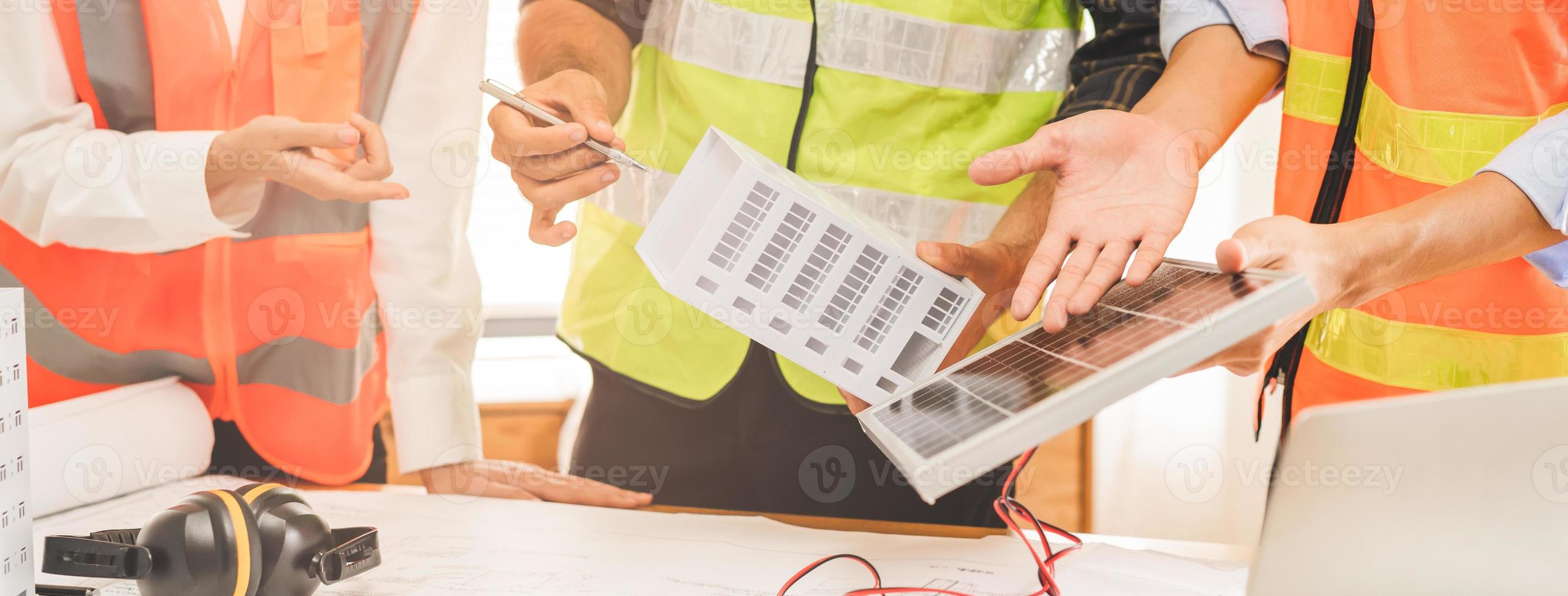 costruzione di ingegnere, architetto giovane uomo d'affari, collega maschio mano nel Tenere solare pannello nel ufficio, incontro Piano Lavorando con compagno squadra costruzione, discutere energia di fotovoltaico progetto foto