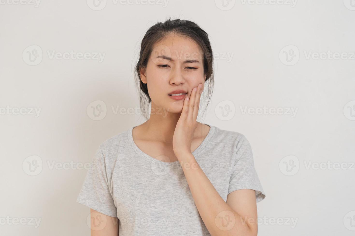 chiusura occhi asiatico giovane donna toccante guancia, viso espressione a partire dal mal di denti, dente decadimento o sensibilità, avendo dente o denti problema o infiammazione, sofferenza a partire dal Salute. sensibile denti persone foto