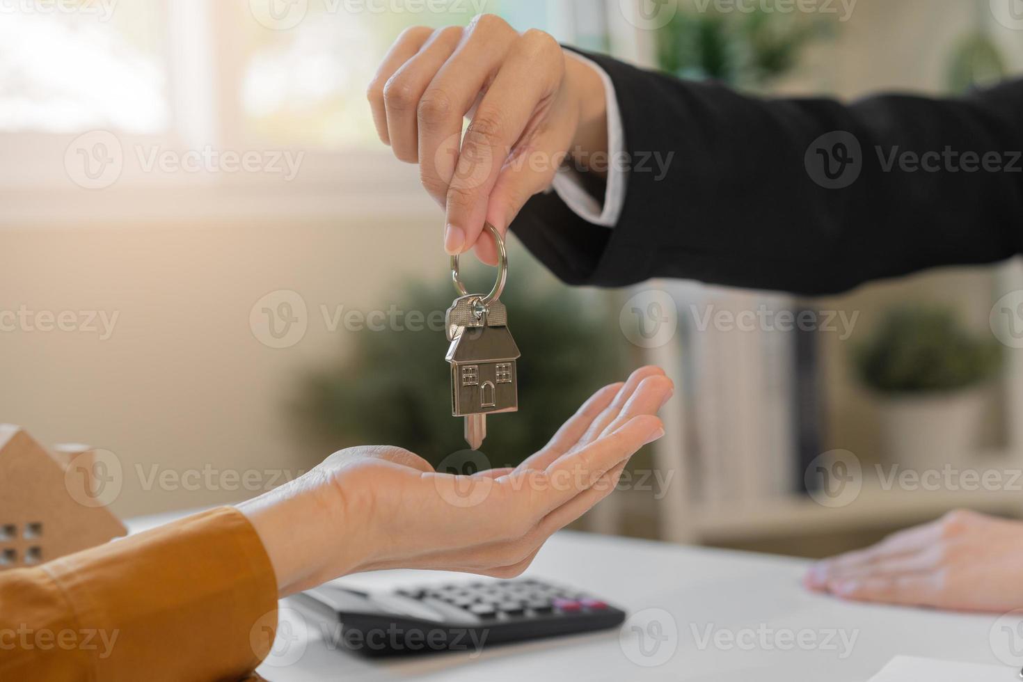 asiatico agente dando un' chiave per nuovo proprietario o inquilino, cliente dopo firmato firma contrarre noleggio Acquista, acquirente appartamento, casa con proprietario, agente immobiliare. banchiere accordo mutuo prestito. proprietà locazione. foto