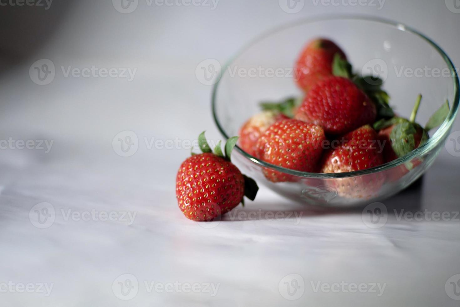 alcuni fragole nel un' bicchiere ciotola, al di fuori il ciotola Là è uno frutta, isolato su bianca foto