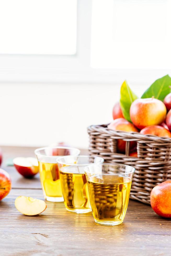 succo di mela in bicchieri e mele nel cestino foto