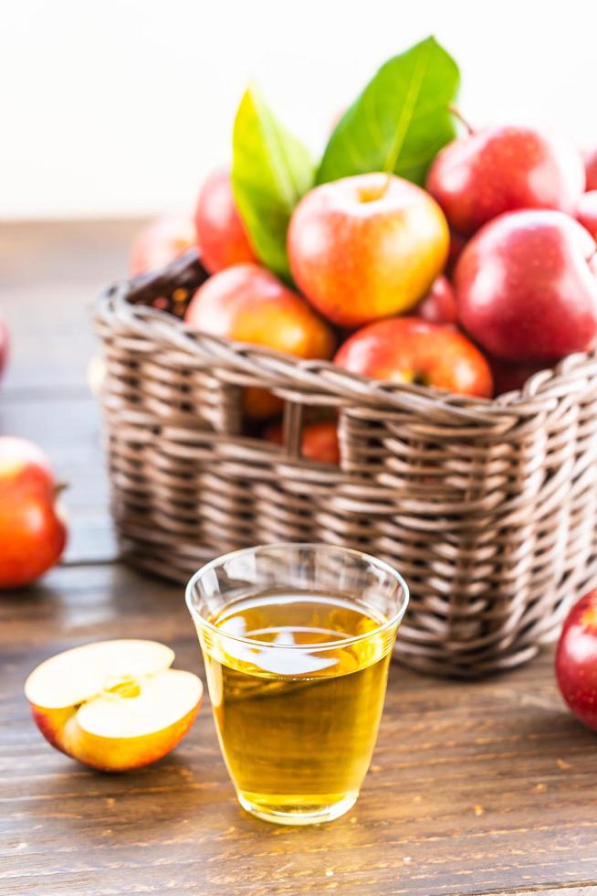 succo di mela in vetro e mele nel cestino foto