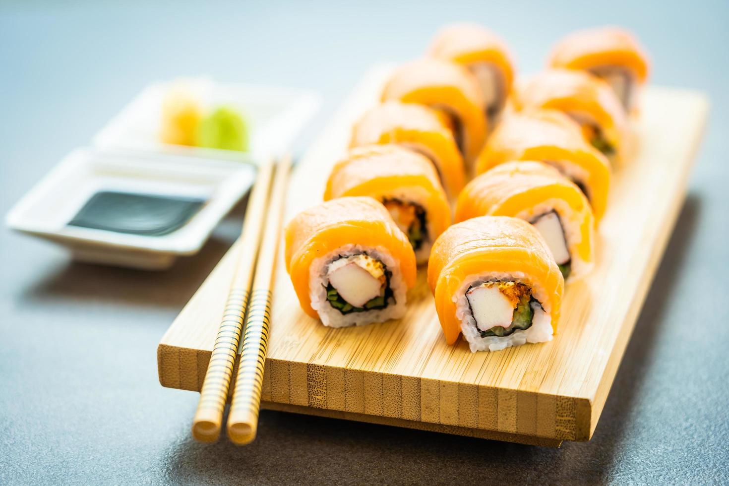 involtini di sushi di salmone sul piatto di legno foto