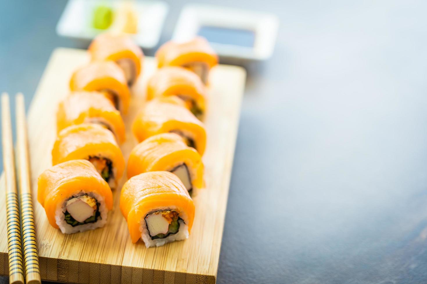 involtini di sushi di salmone sul piatto di legno foto