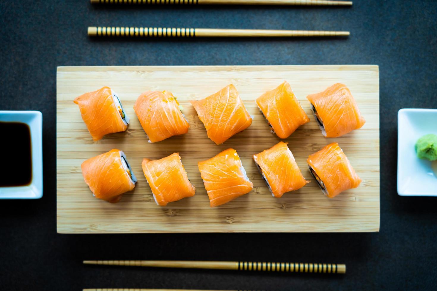 involtini di sushi di salmone sul piatto di legno foto