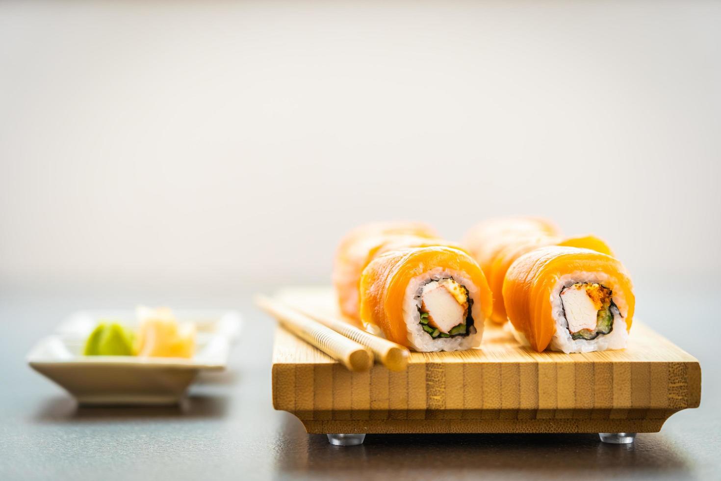 involtini di sushi di salmone sul piatto di legno foto