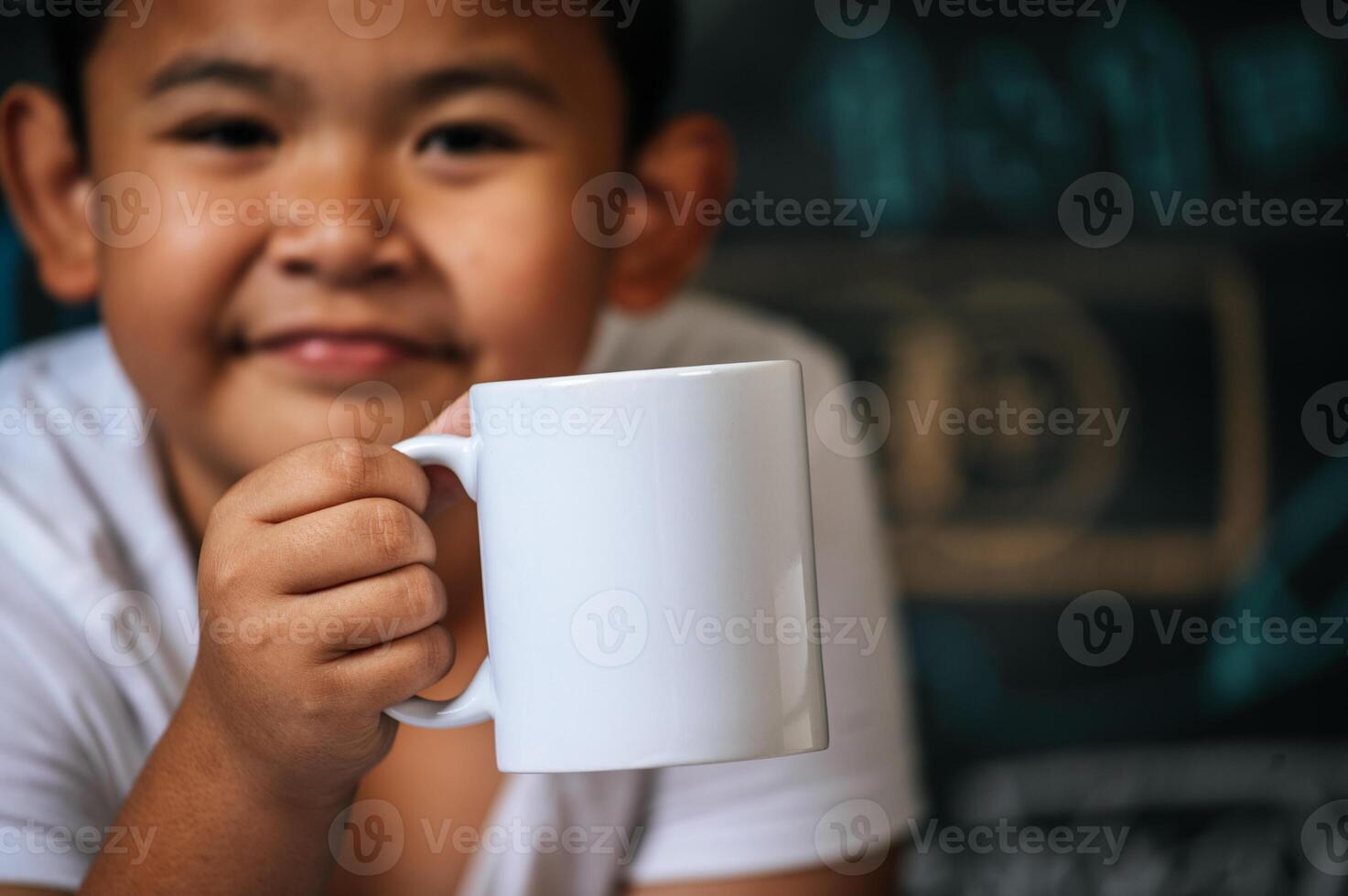 bambino seduto e tenendo la tazza in classe foto