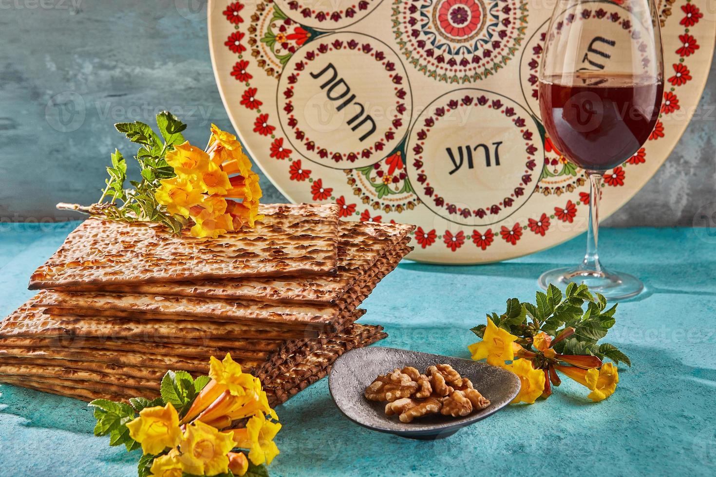 Pesach celebrazione concetto - ebraico vacanza pesach. sfondo con giallo fiori con bicchiere di vino, matzah e piatto di seder nel il raggi di il sole. tradizionale ebraico iscrizioni su piatto foto