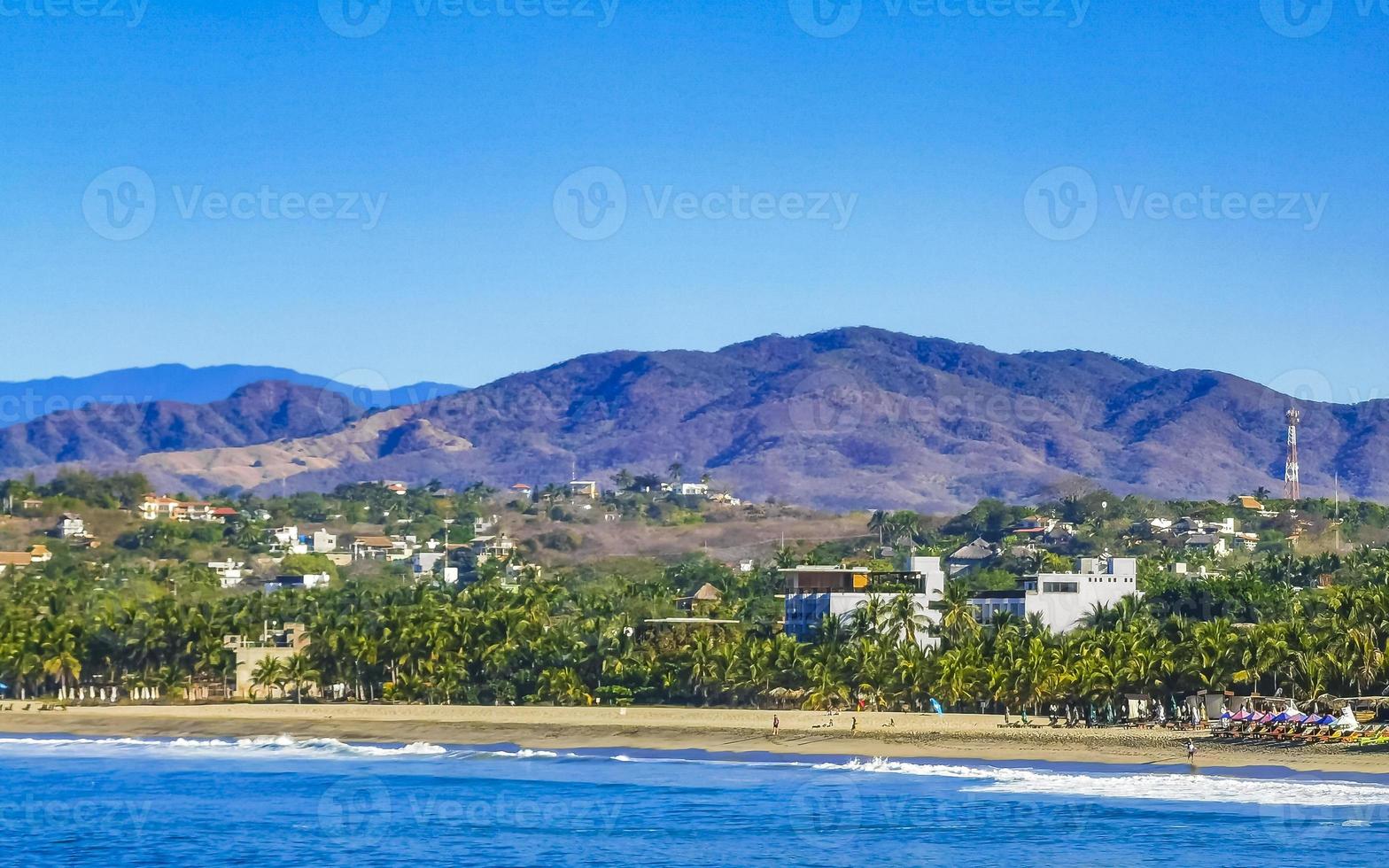 sole spiaggia scogliere rocce onde palme montagne puerto escondido Messico. foto