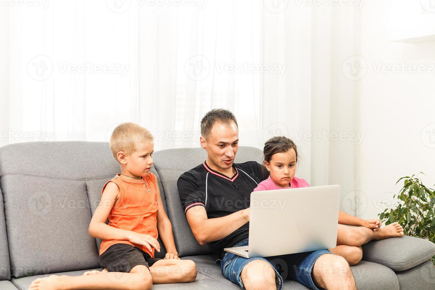 padre e bambini cartone animato in linea a computer portatile, papà la spesa tempo insieme con ragazzo giocando gioco con papà godendo mattina a casa foto