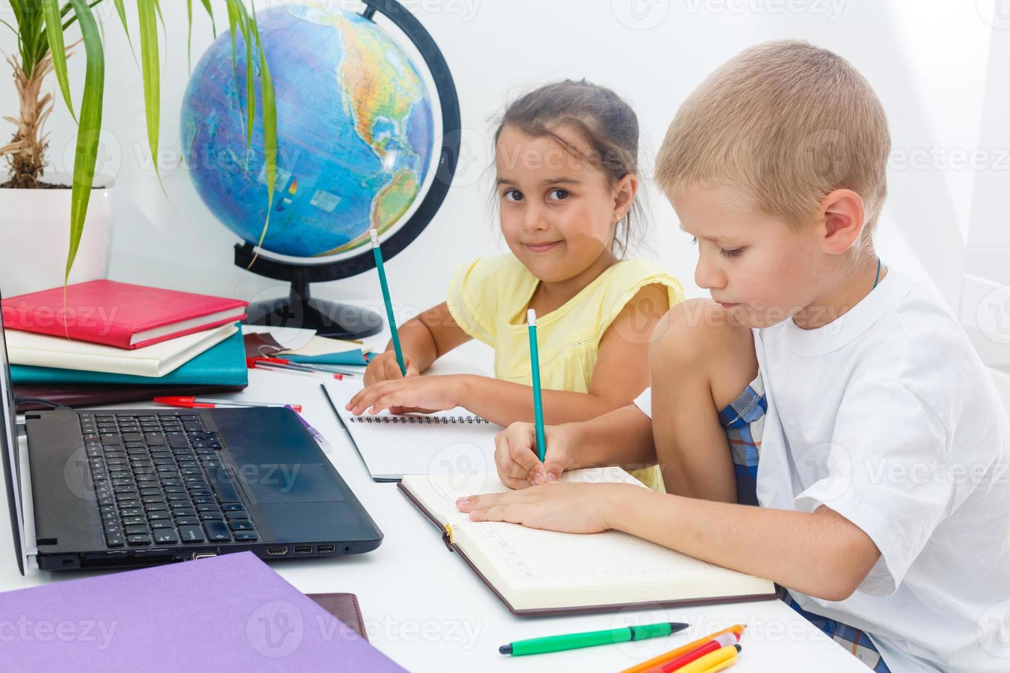 covid-19 coronavirus e apprendimento a partire dal casa, casa scuola ragazzo concetto. poco bambini studia in linea apprendimento a partire dal casa con il computer portatile. quarantena e sociale distanziamento concetto. foto