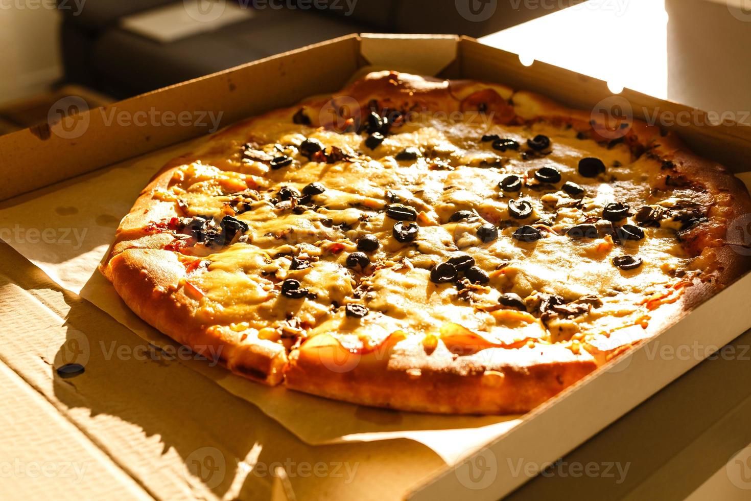 fresco Pizza nel cartone scatola su di legno tavolo avvicinamento foto