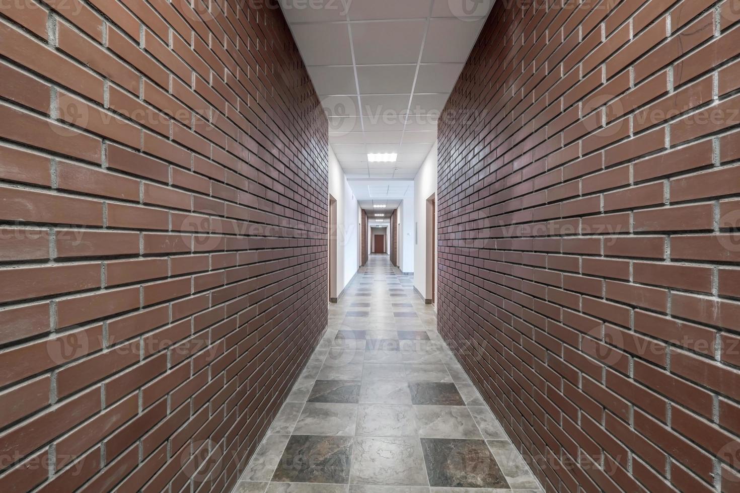 vuoto lungo corridoio con rosso mattone muri nel interno di moderno appartamenti, ufficio o clinica. foto