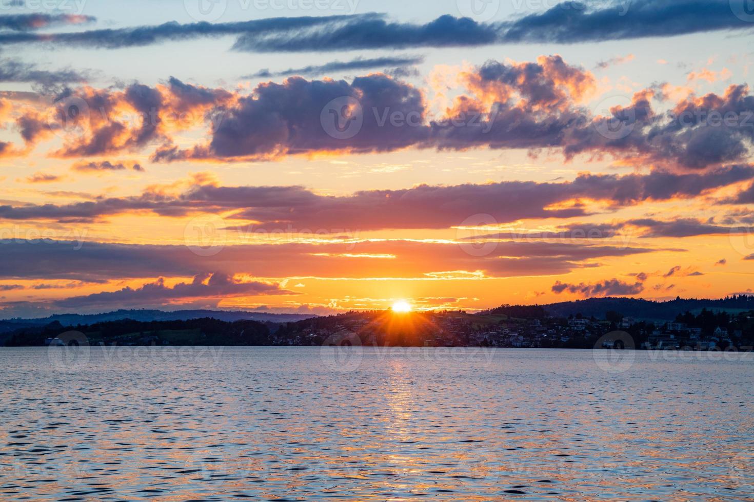 un' tramonto a il lago con viola rosso nuvole foto