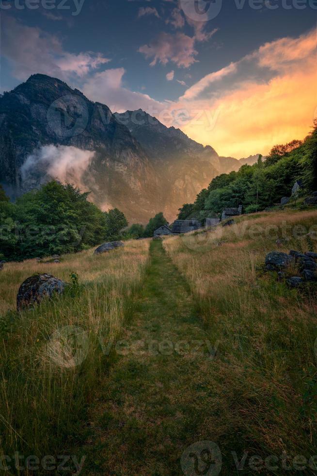 un' verde escursioni a piedi pista durante un' tramonto fra montagne foto