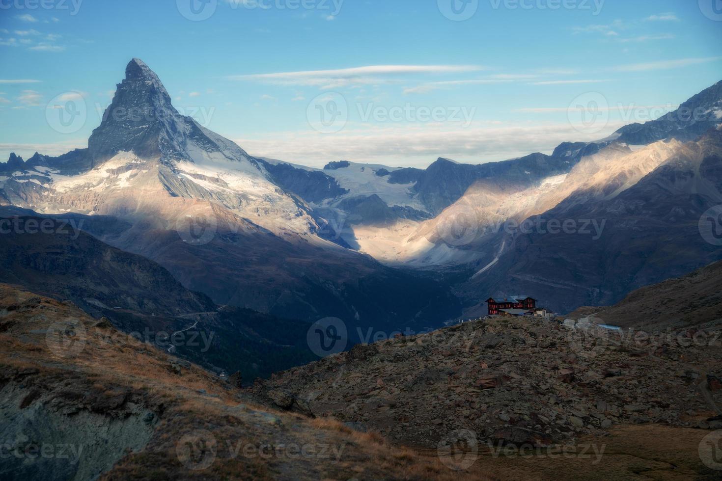 Zermatt montagna paesaggio, il montagne siamo illuminato di il sole.in il distanza sta un Locanda foto