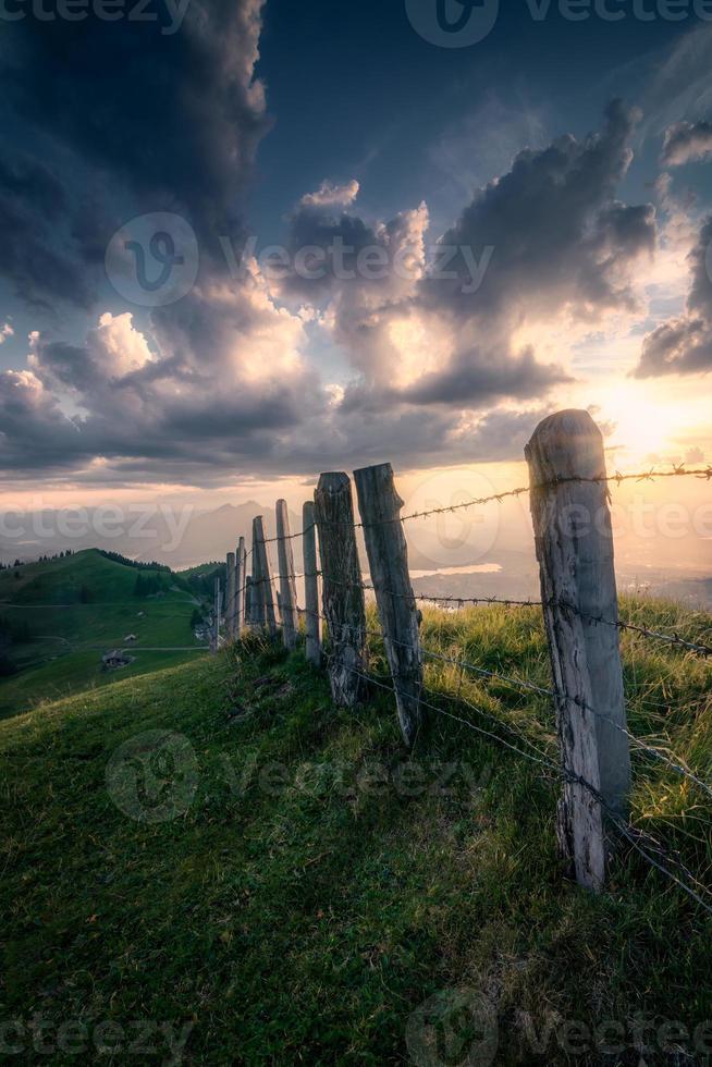 tramonto su un' montagna con un vecchio recinto foto