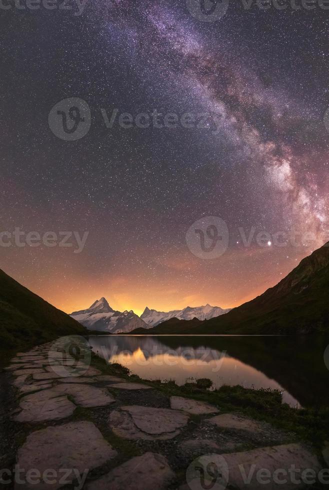 un' montagna lago durante notte con il latteo modo foto