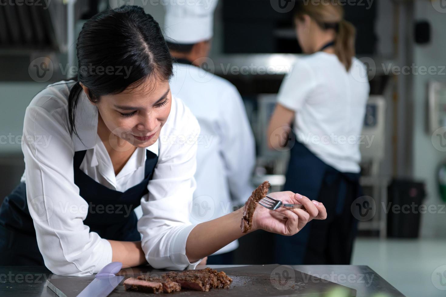 ritratto di alunno cucinando apprendista prendere Appunti su ogni passo come il capocuoco cuochi nel il culinario dell'accademia cucina. foto