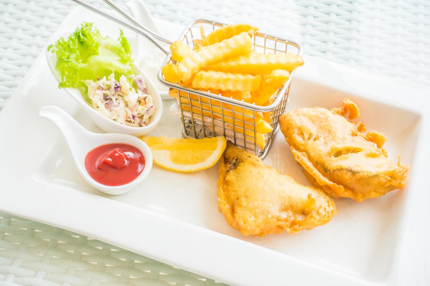 pesce e patatine fritte su un piatto bianco foto