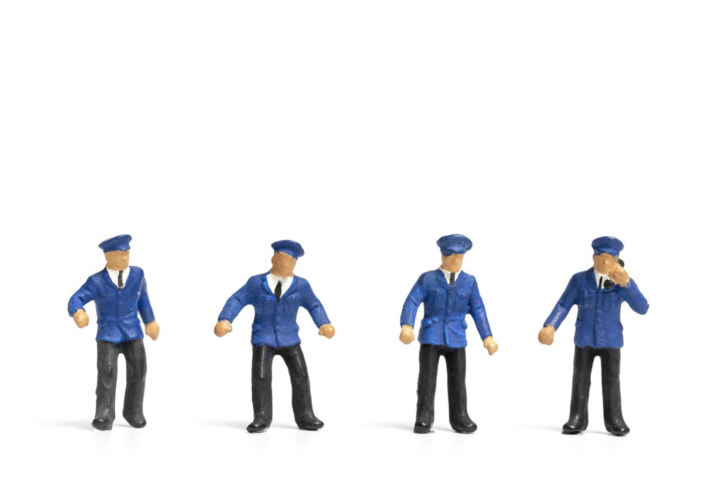 poliziotti in miniatura in piedi su uno sfondo bianco foto