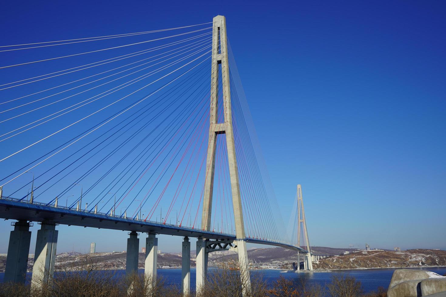 paesaggio con vista sul ponte russky contro un cielo blu chiaro a vladivostok, russia foto