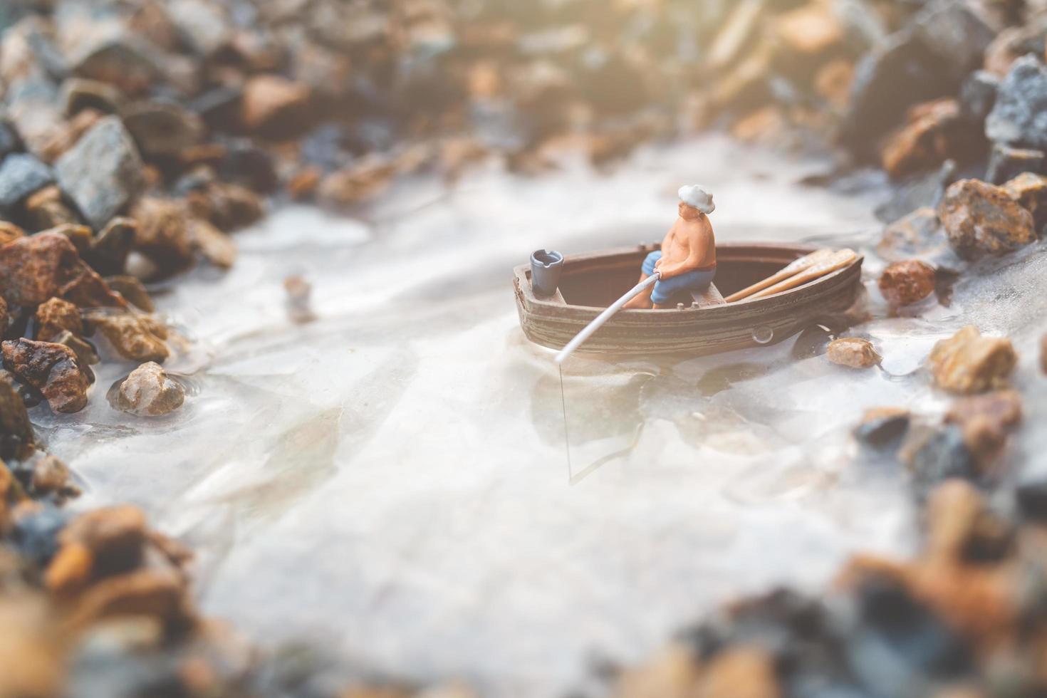 pescatore in miniatura che pesca su una barca foto