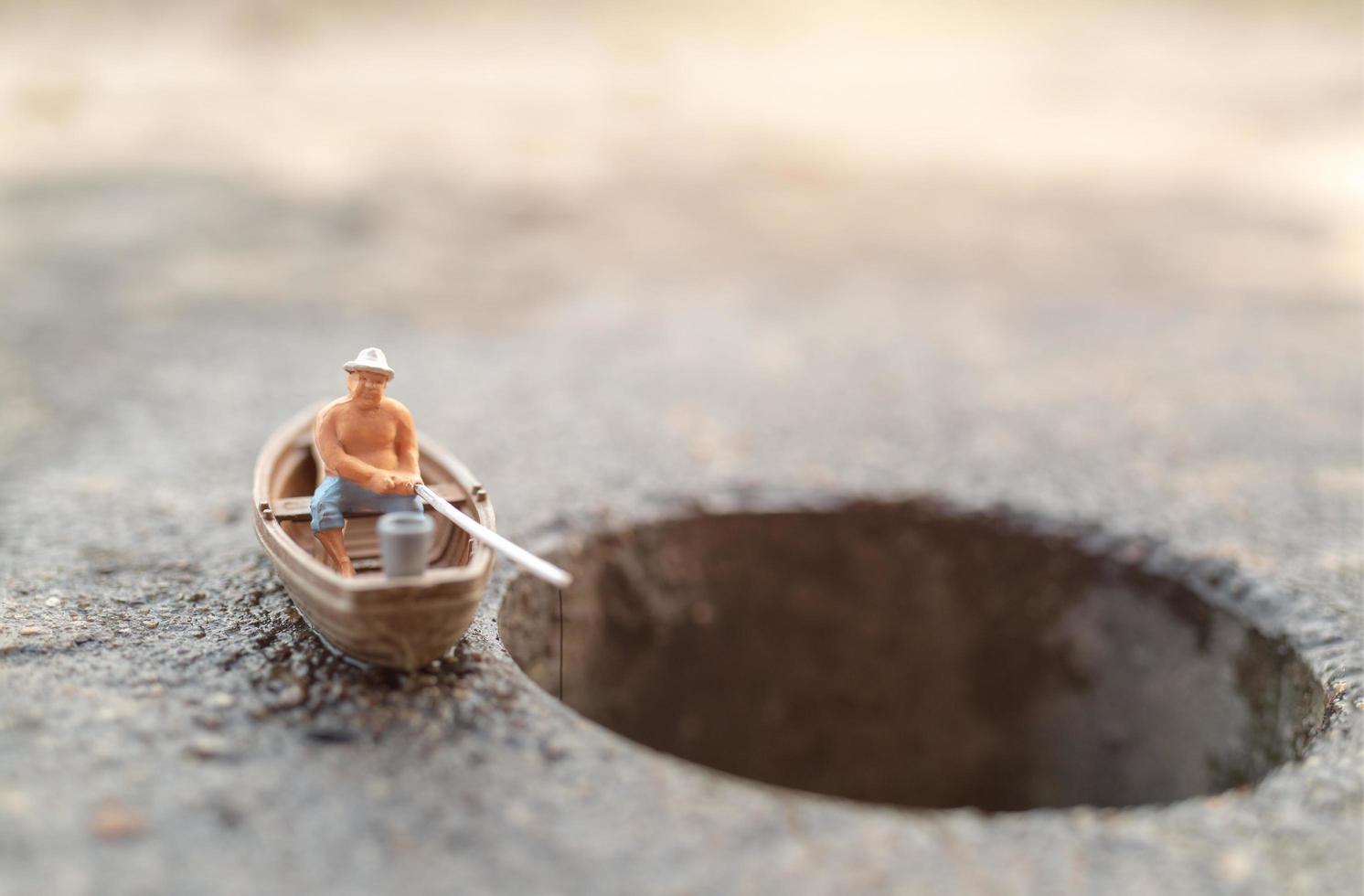 pescatore in miniatura che pesca su una barca foto