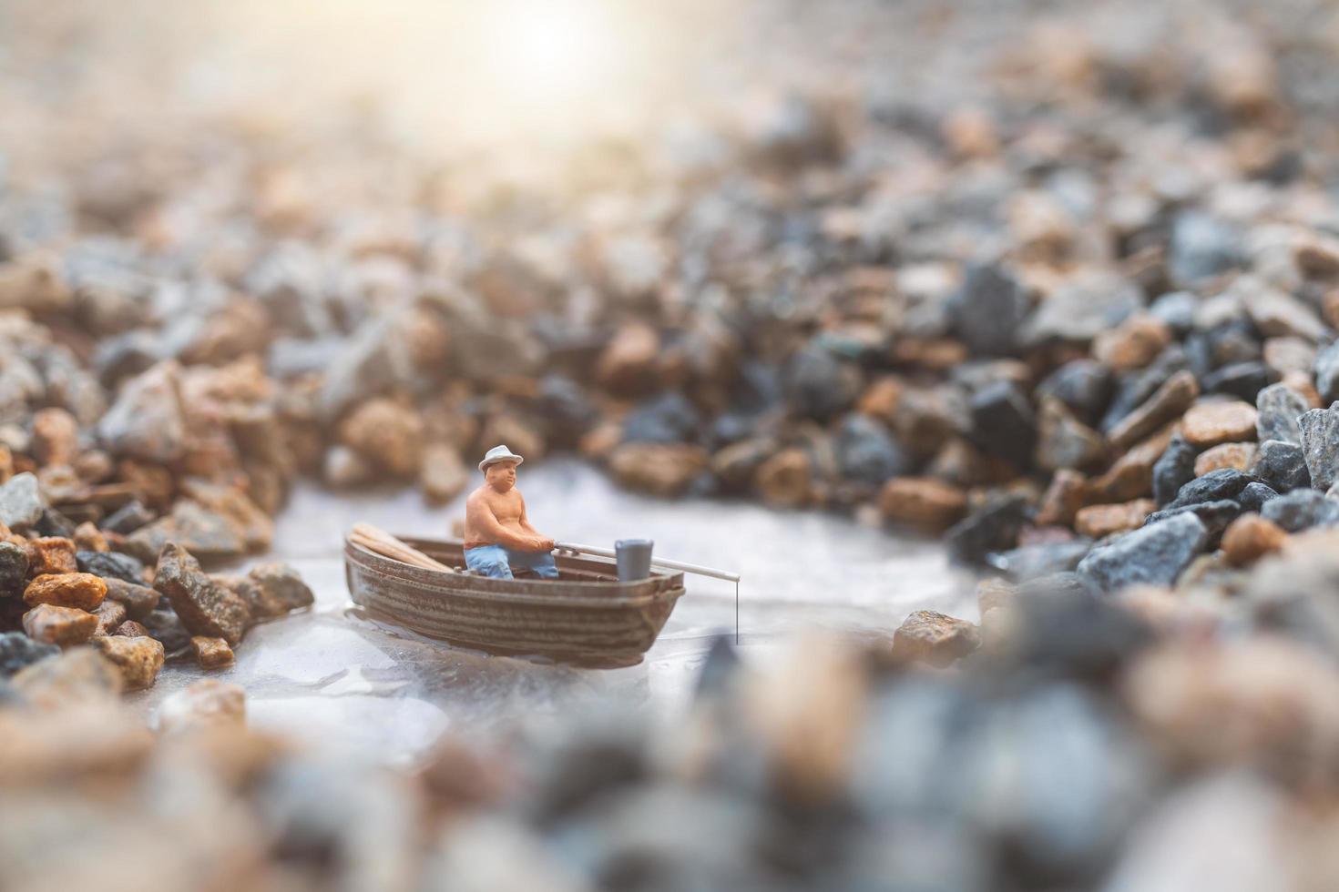 pescatore in miniatura che pesca su una barca foto