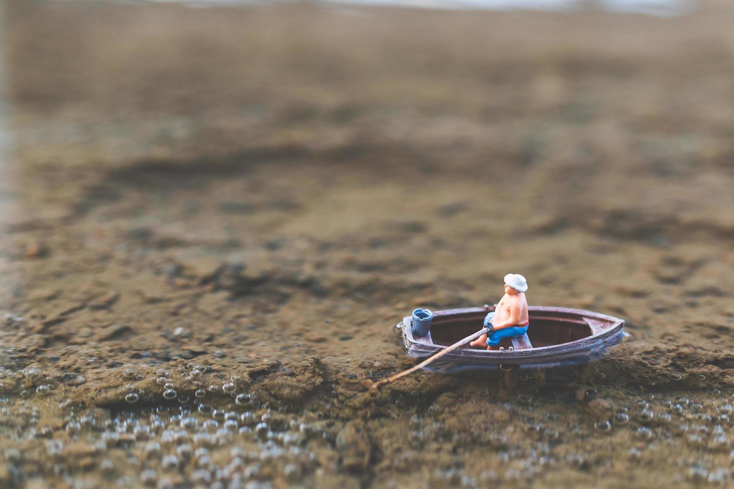 pescatore in miniatura che pesca su una barca foto