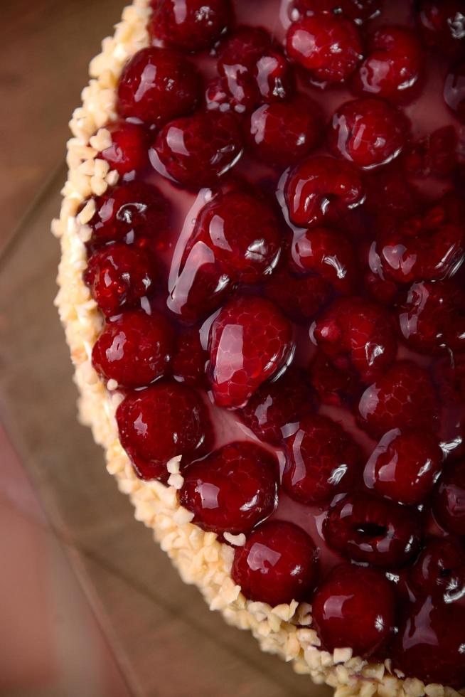 torta di lamponi con noci sul tavolo di legno foto