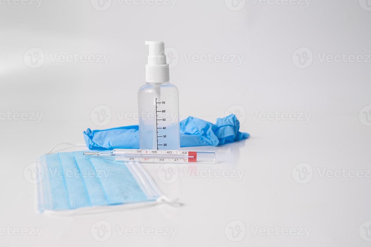 mascherina chirurgica con guanti, termometro e gel disinfettante foto