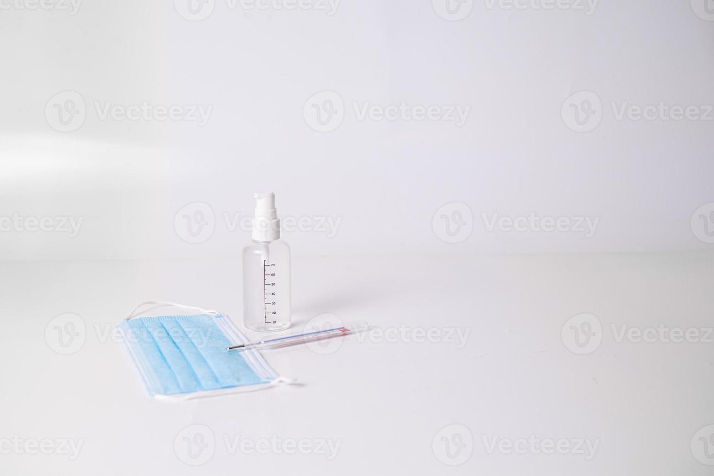 mascherina chirurgica con termometro e gel disinfettante foto