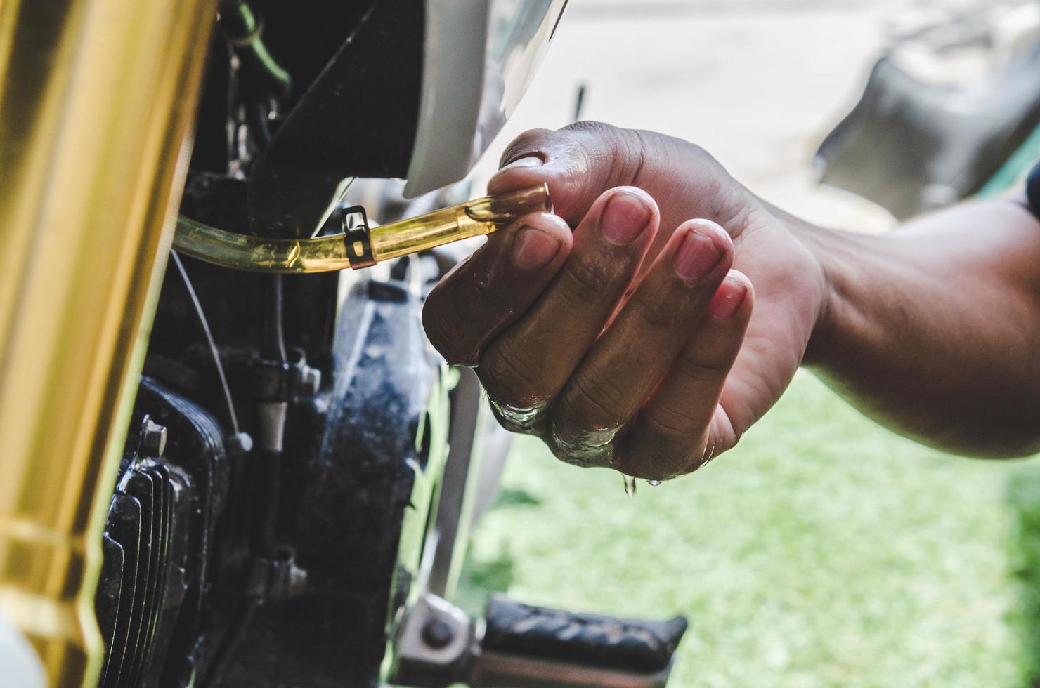 uomo che ripara moto foto