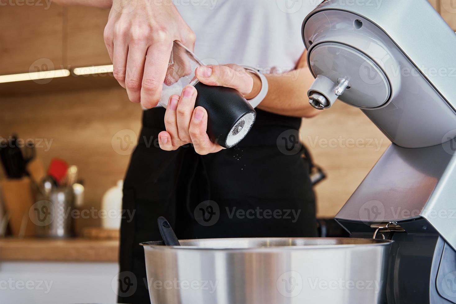 donna cucinando a cucina e utilizzando cucina macchina foto