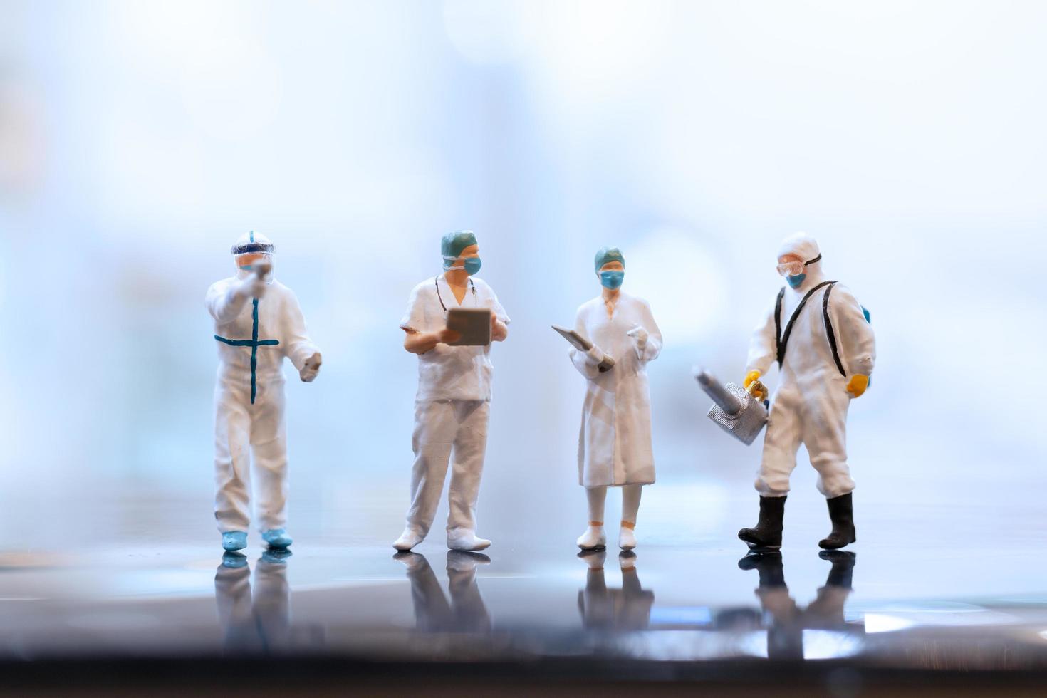 medici in miniatura che indossano maschere facciali durante il coronavirus e l'epidemia di influenza, il concetto di protezione da virus e malattie foto