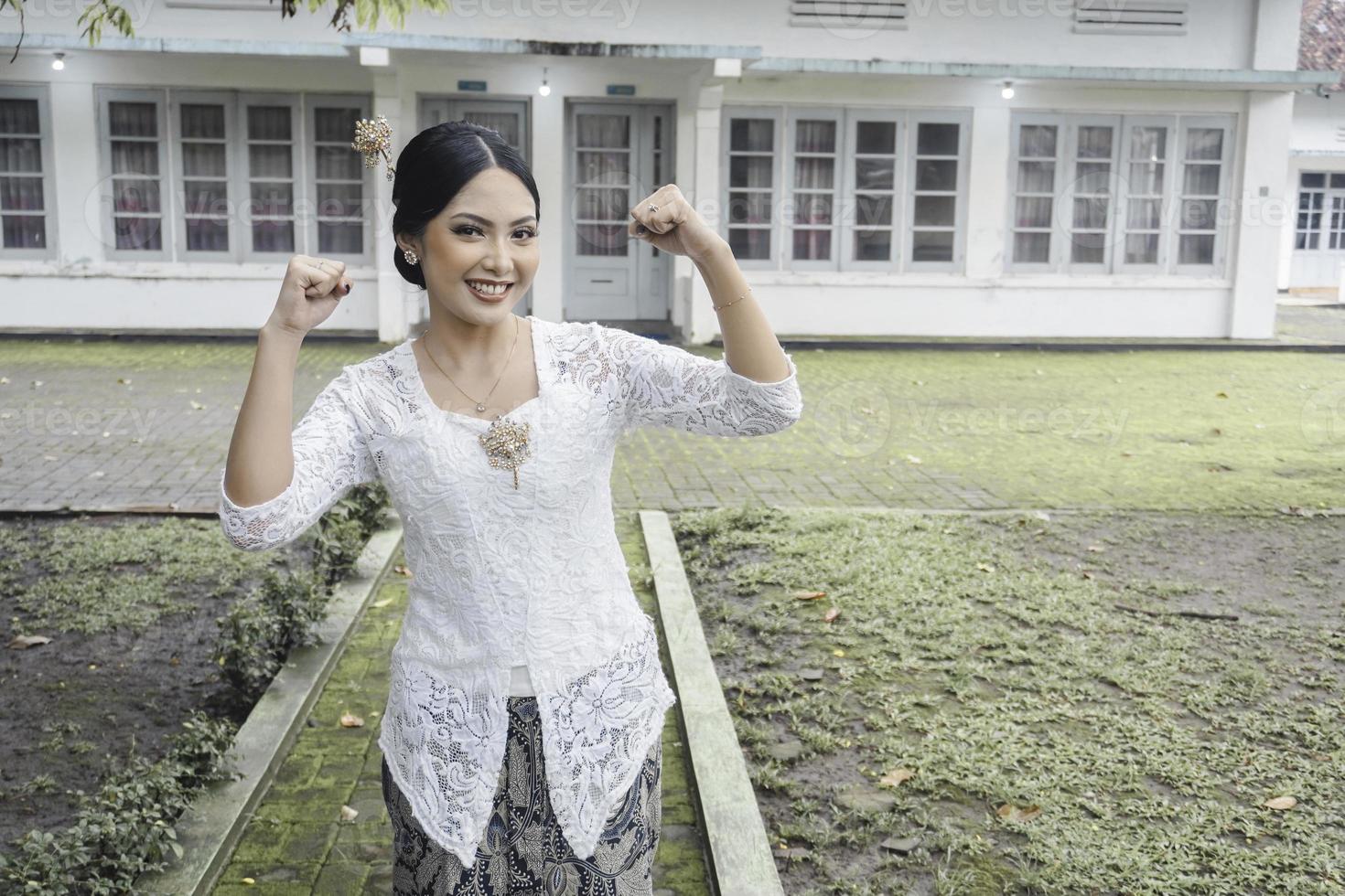 un' giovane indonesiano donna con un' contento riuscito espressione indossare un' bianca kebaya. di Kartini giorno concetto. foto