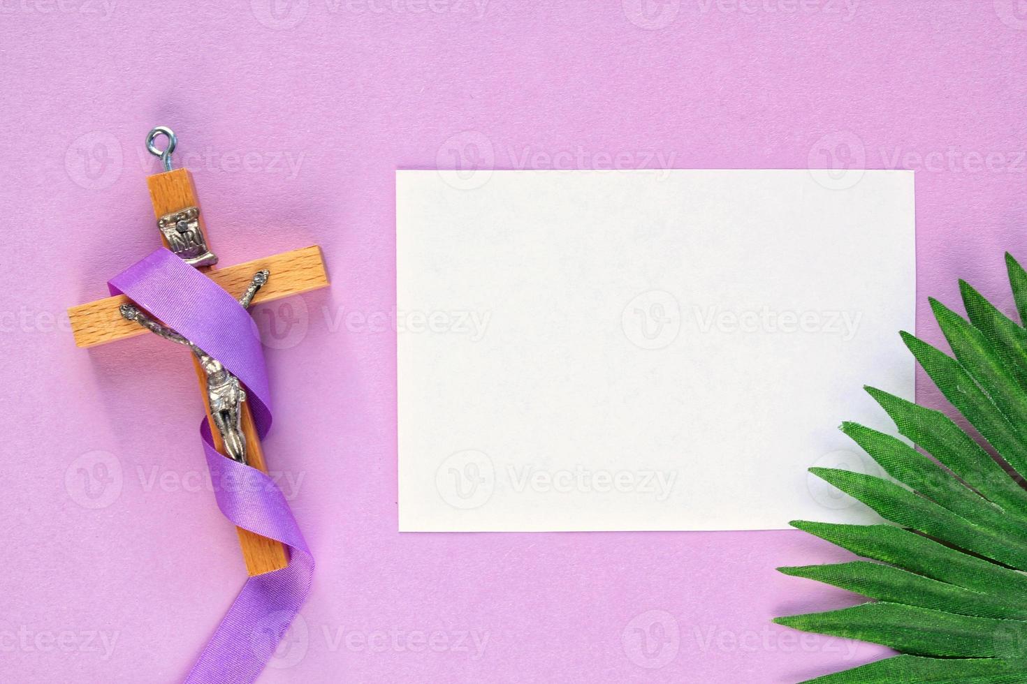 cristiano religioso di legno attraversare crocifisso con viola nastro e palma foglia su viola sfondo. cattolico religione simbolo. bene venerdì, prestato stagione, palma domenica, cenere mercoledì e santo settimana concetto. foto