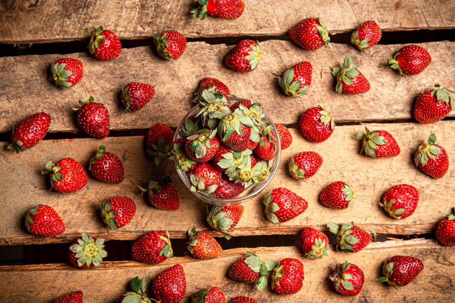 fragole in un bicchiere e su un tavolo foto