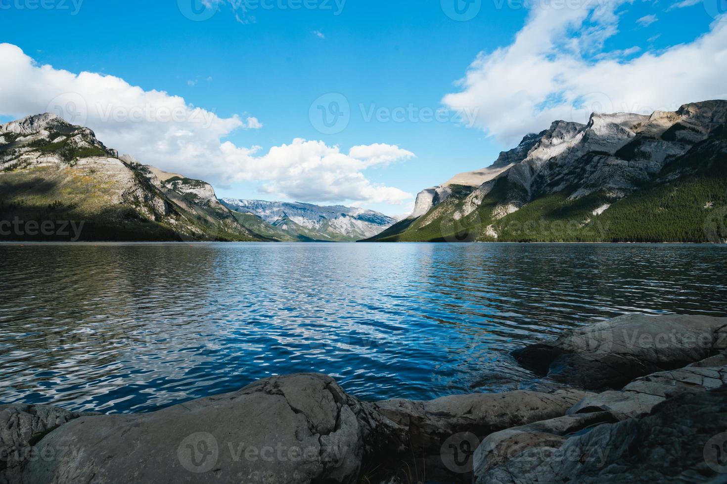 lago minnewanka nel alberta, Canada su un' nuvoloso giorno con sbalorditivo montagne e acqua riflessi foto