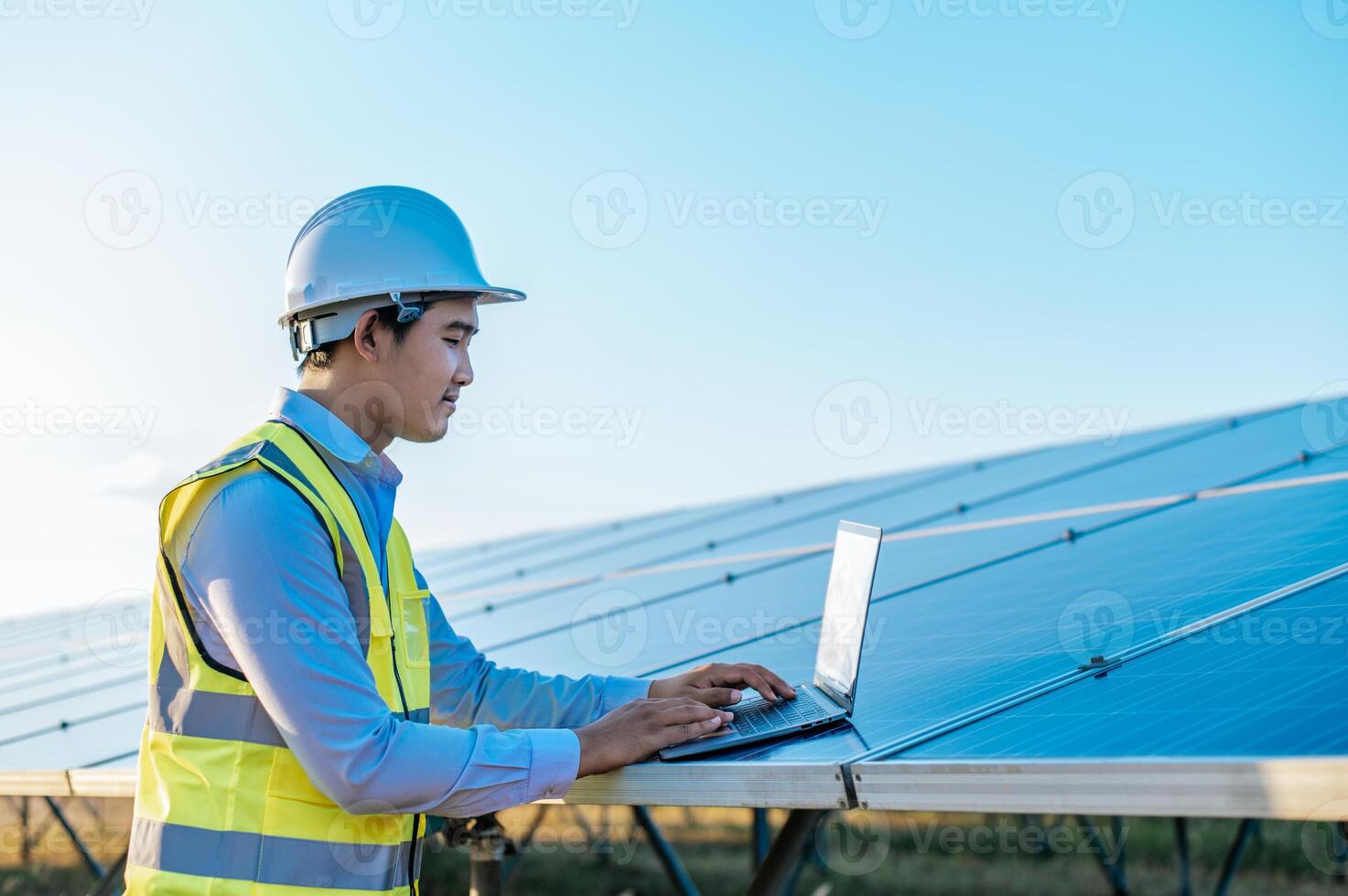 giovane tecnico uomo Lavorando su il computer portatile nel solare azienda agricola foto