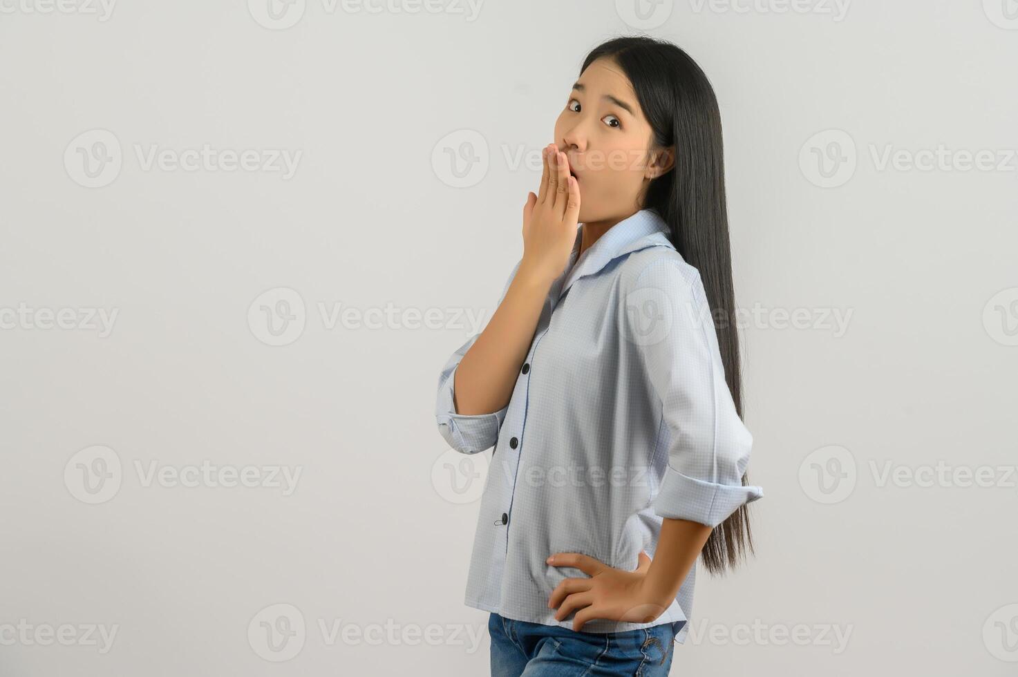 ritratto di giovane sorpreso asiatico donna nel blu camicia mette sua mano al di sopra di sua bocca isolato su bianca sfondo foto