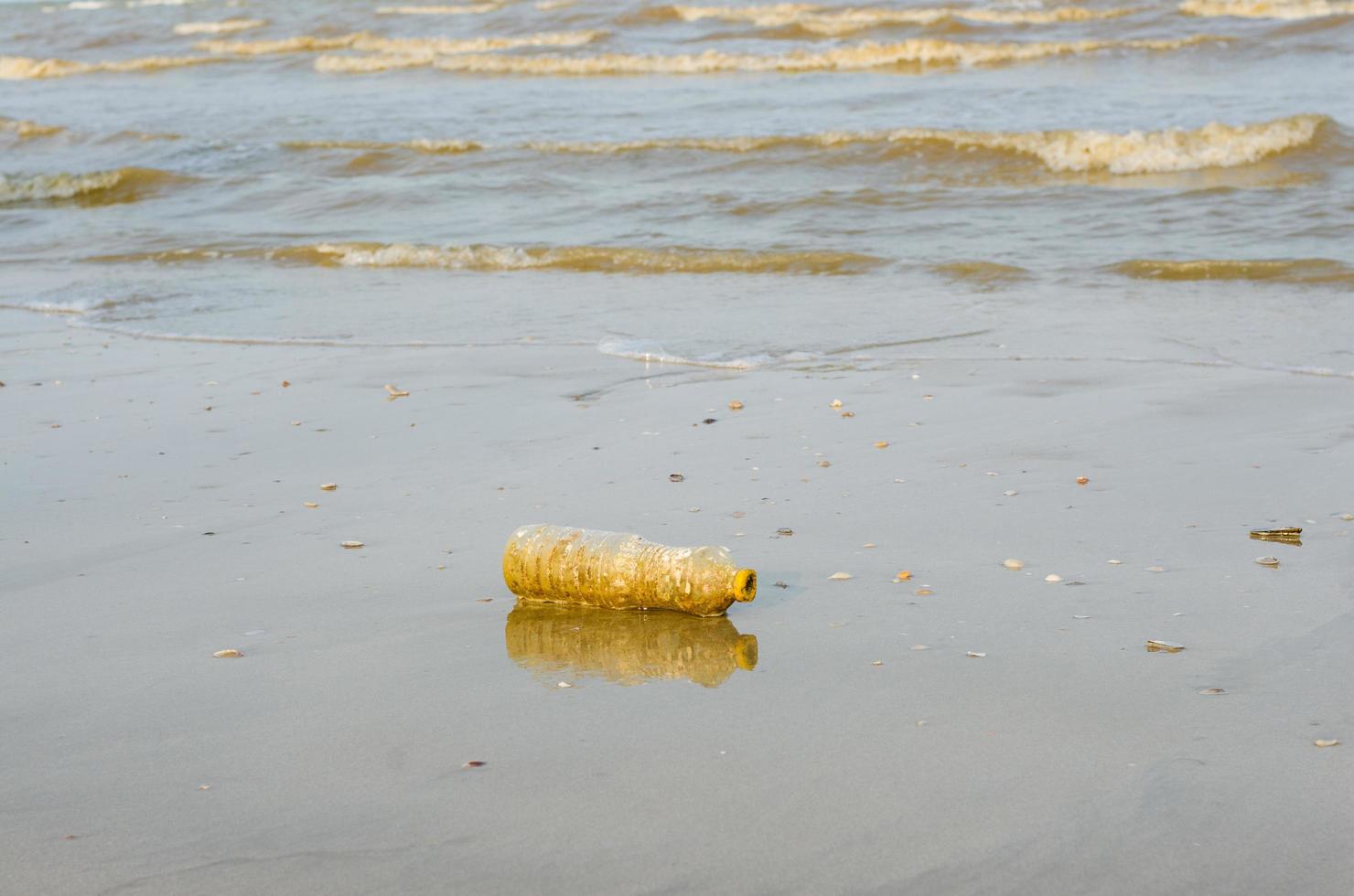 plastica bottiglia rifiuto su spiaggia per inquinamento concetto foto