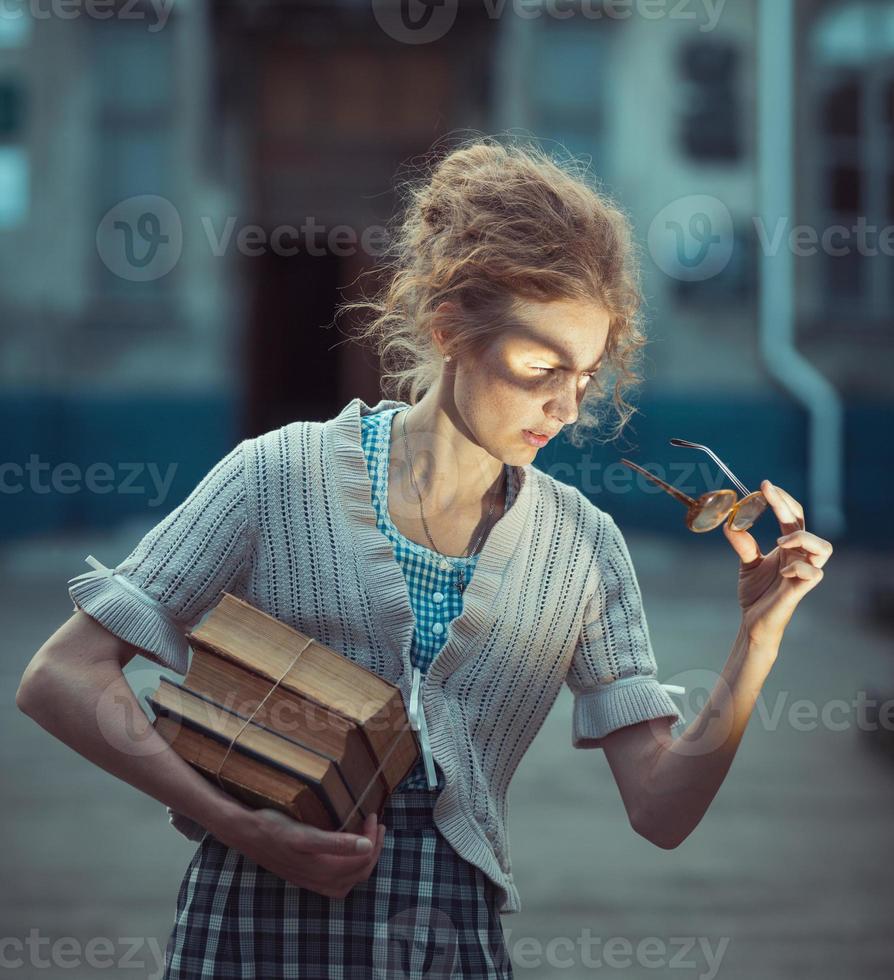 divertente ragazza alunno con libri e bicchieri e un' Vintage ▾ vestito foto