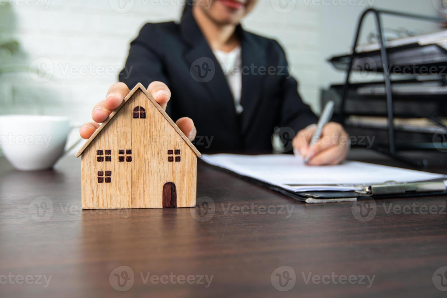 imprenditrice in possesso di un modello di casa e la firma di un contratto foto