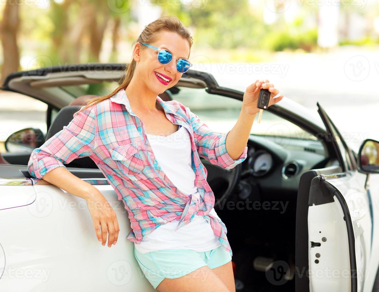 giovane bella donna è in piedi vicino il convertibile auto con il chiavi nel mano foto