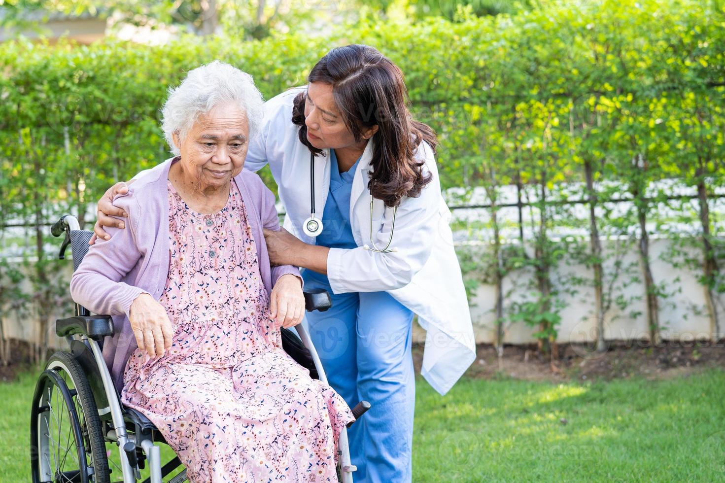 badante Aiuto e cura asiatico anziano donna paziente seduta su sedia a rotelle a assistenza infermieristica ospedale reparto, salutare forte medico concetto. foto