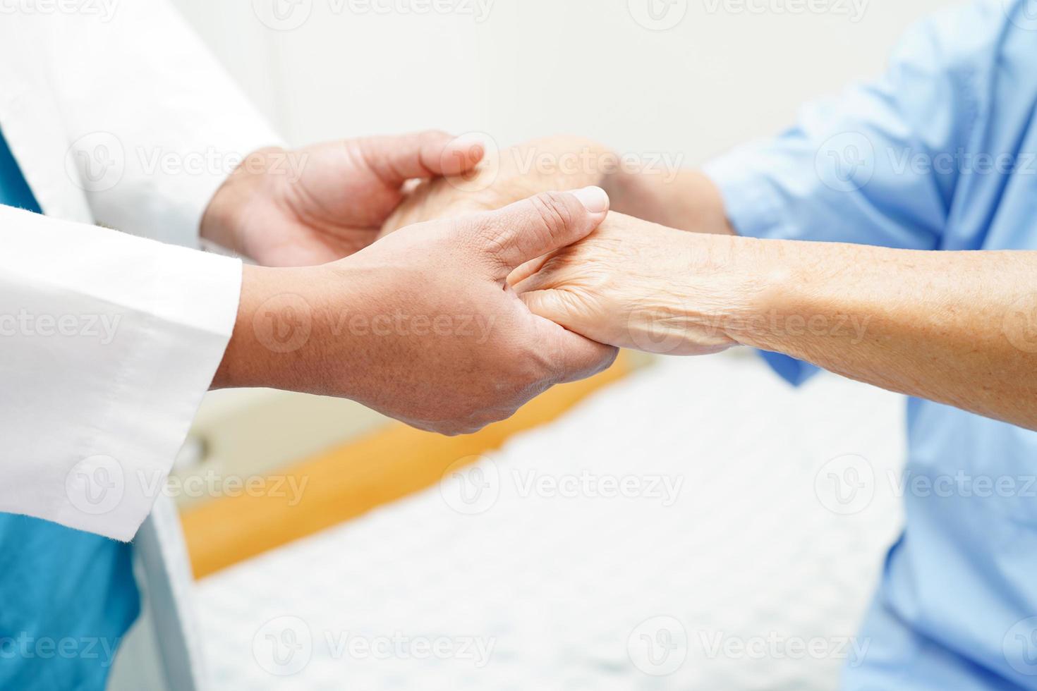 medico che si tiene per mano paziente donna anziana asiatica, aiuto e cura in ospedale. foto