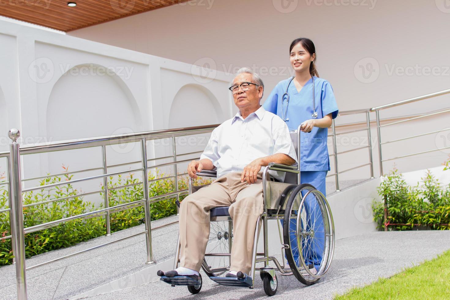 assistenza infermieristica casa cura concetto. asiatico giovane infermiera Disabilitato anziano uomo. infermiera, cura casa e anziano uomo con invalidità nel un' sedia a rotelle nel un al di fuori medico facilità. foto