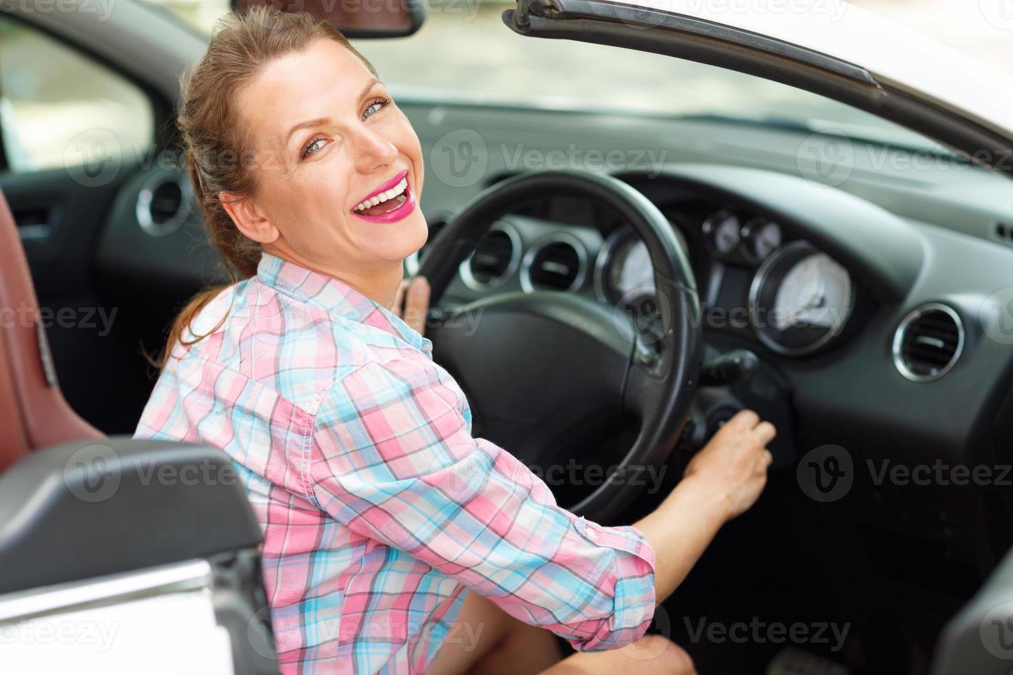 giovane bellissimo donna seduta nel un' convertibile e è andando per inizio il motore foto